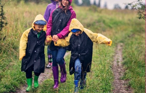 Image of family walking in rain wearing wellies and raincoats